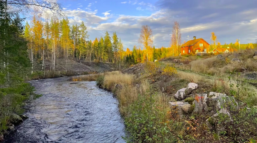 Solfors, rött torp vid forsen i höstskog